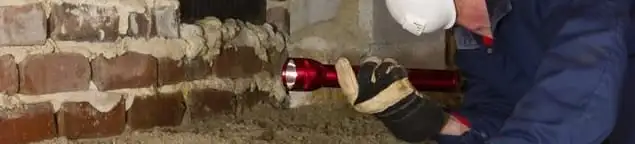 Pest control technician inspecting a crawl space for ant activity and entry points in Chandler, AZ